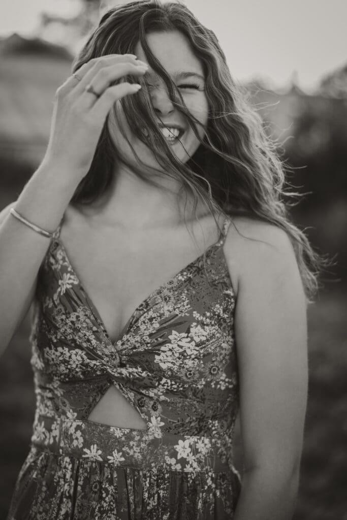 black and white photo girl laughing hair in her face