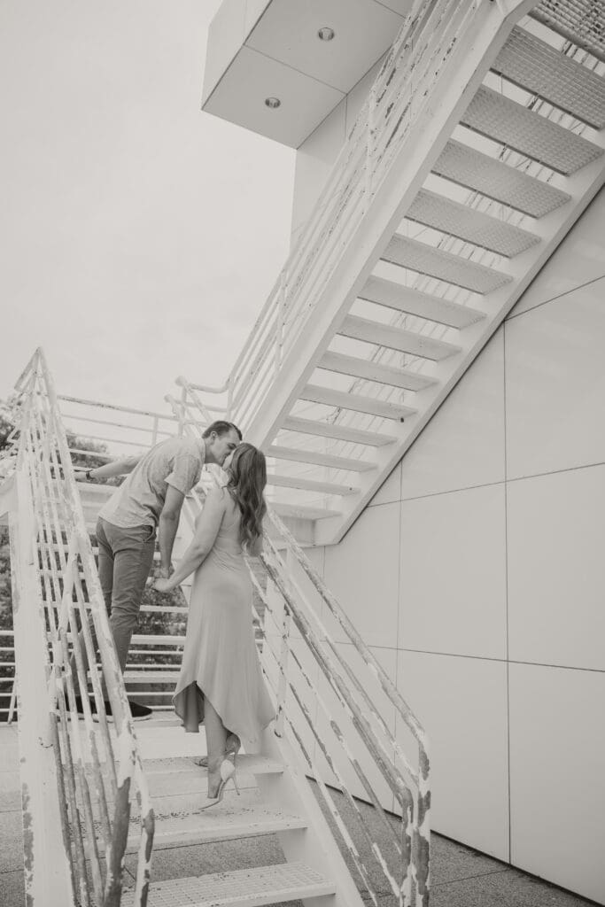 black and white photo of couple on stairs kissing relaxing session