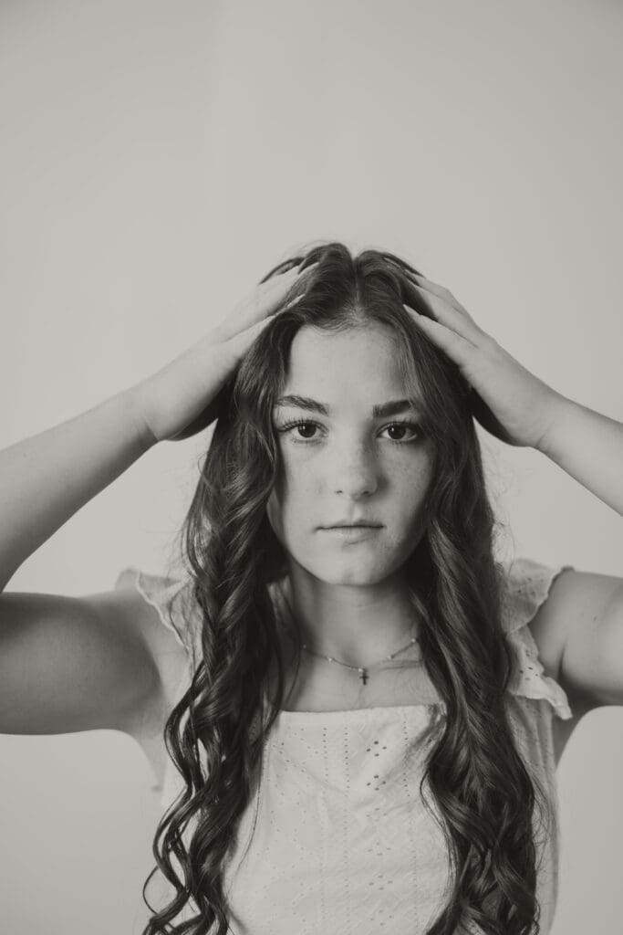 black and white image of senior girl poofing hair