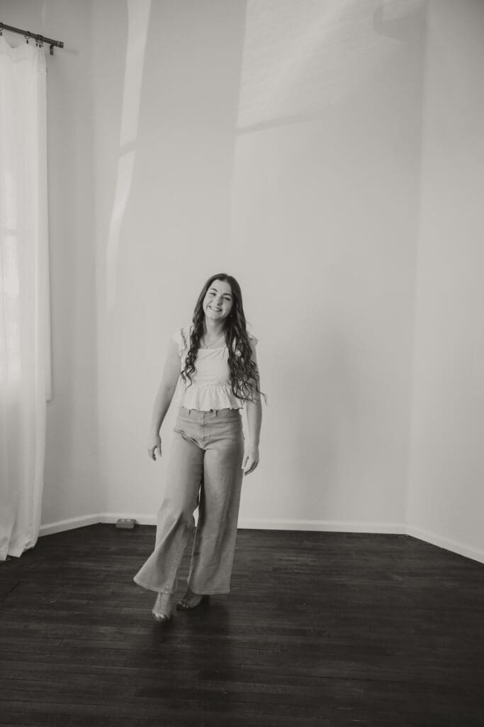 black and white photo of senior girl walking for indoor studio session