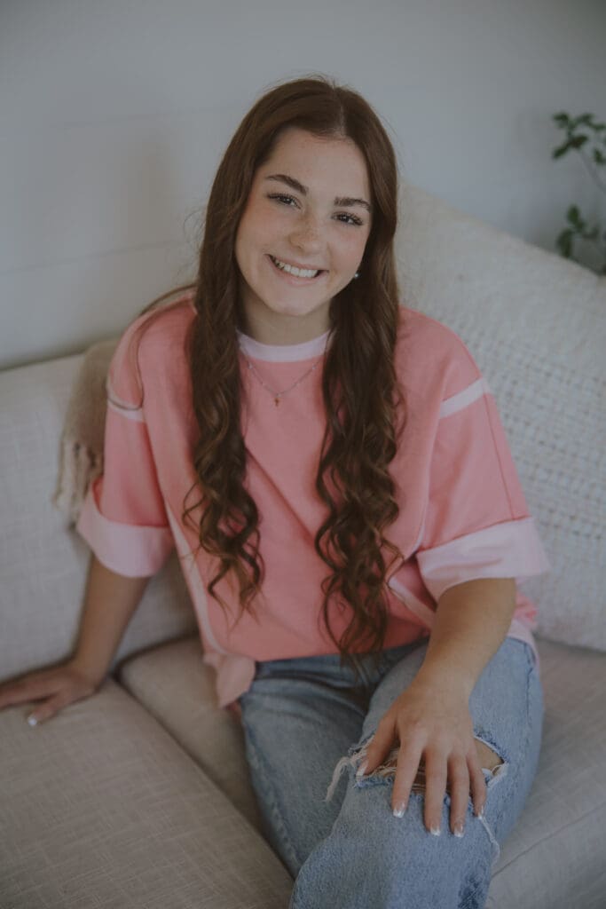 studio senior girl session pink shirt long brown hair smiling