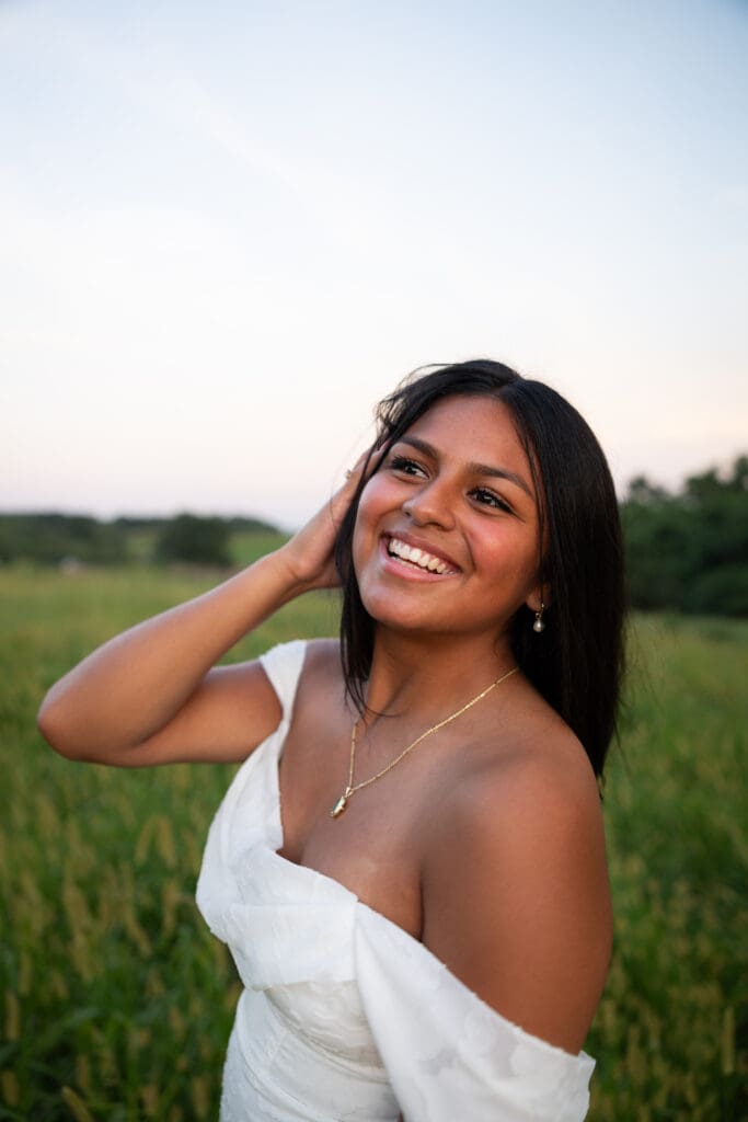 Senior Girl laughing in white dress in field