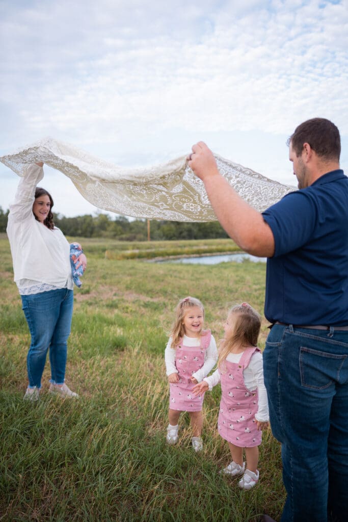Family photo session kids playing under blanket