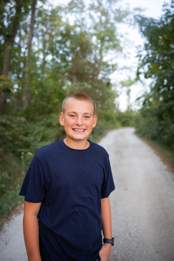 Older son smiling during outdoor Iowa family session.