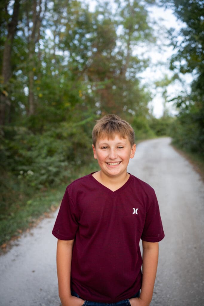Younger son smiling during outdoor Iowa family session.