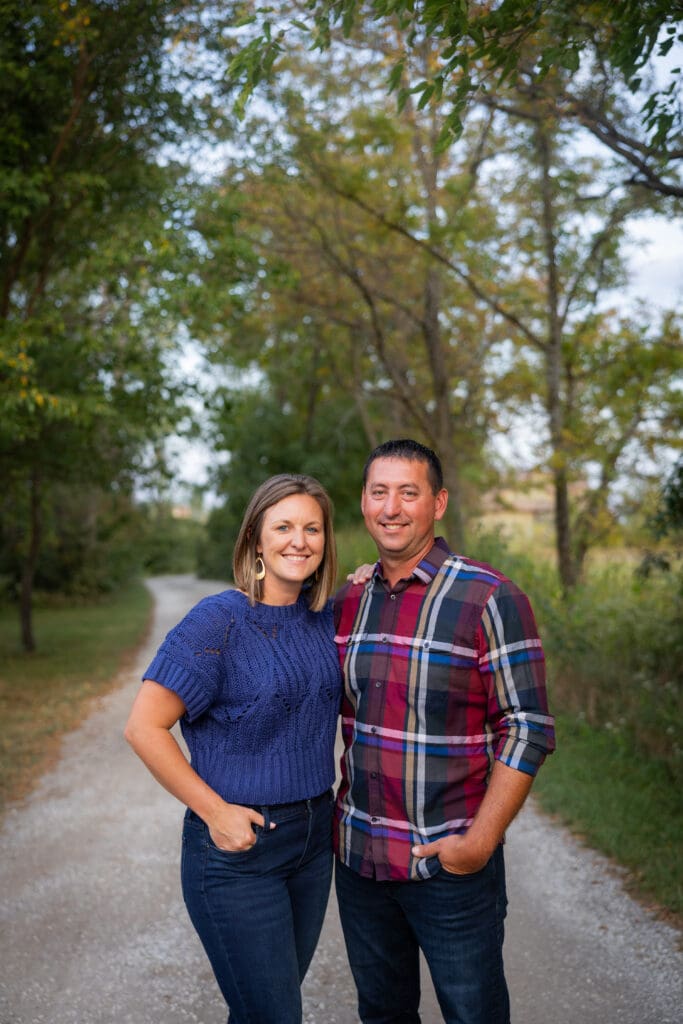 Couple standing back-to-back on gravel lane during family session.