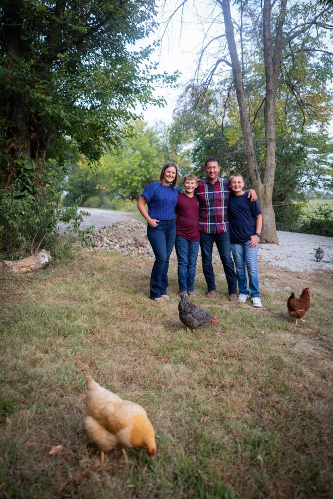 Family with chickens on their rural Iowa property during outdoor session.