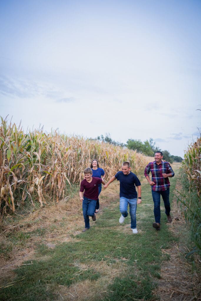 family racing down lane near corn field