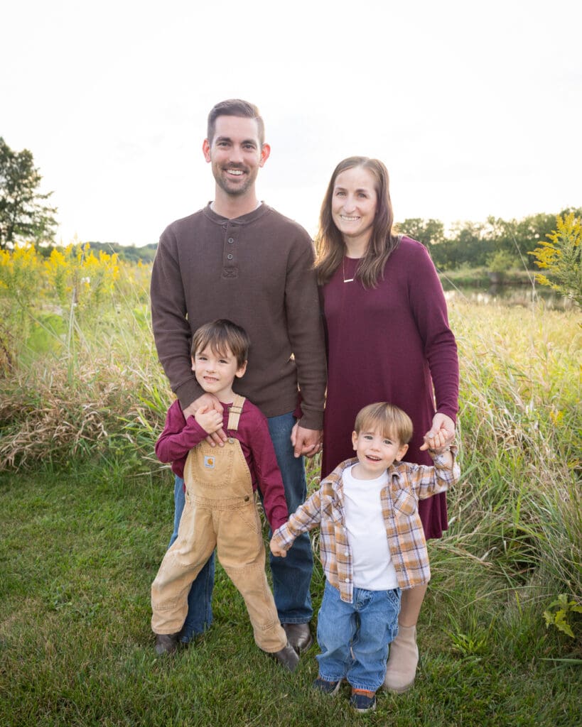 Family standing together in a field at sunset on their Fairfield, Iowa property.