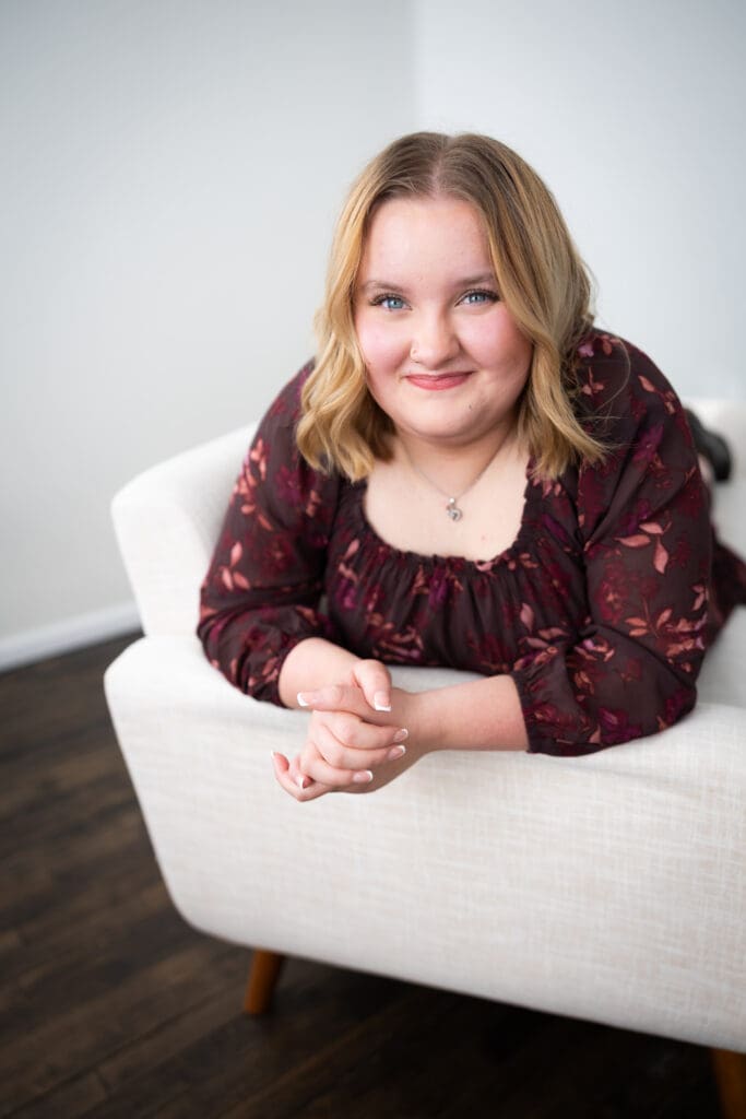 senior girl leaning on couch for studio session
