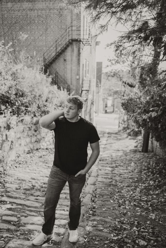 black and white senior guy photo walking up stone alley