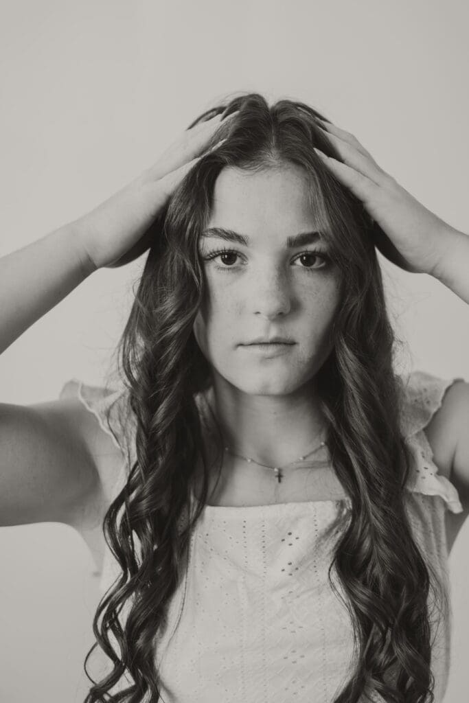 senior girl studio black and white pushing up hair serious face