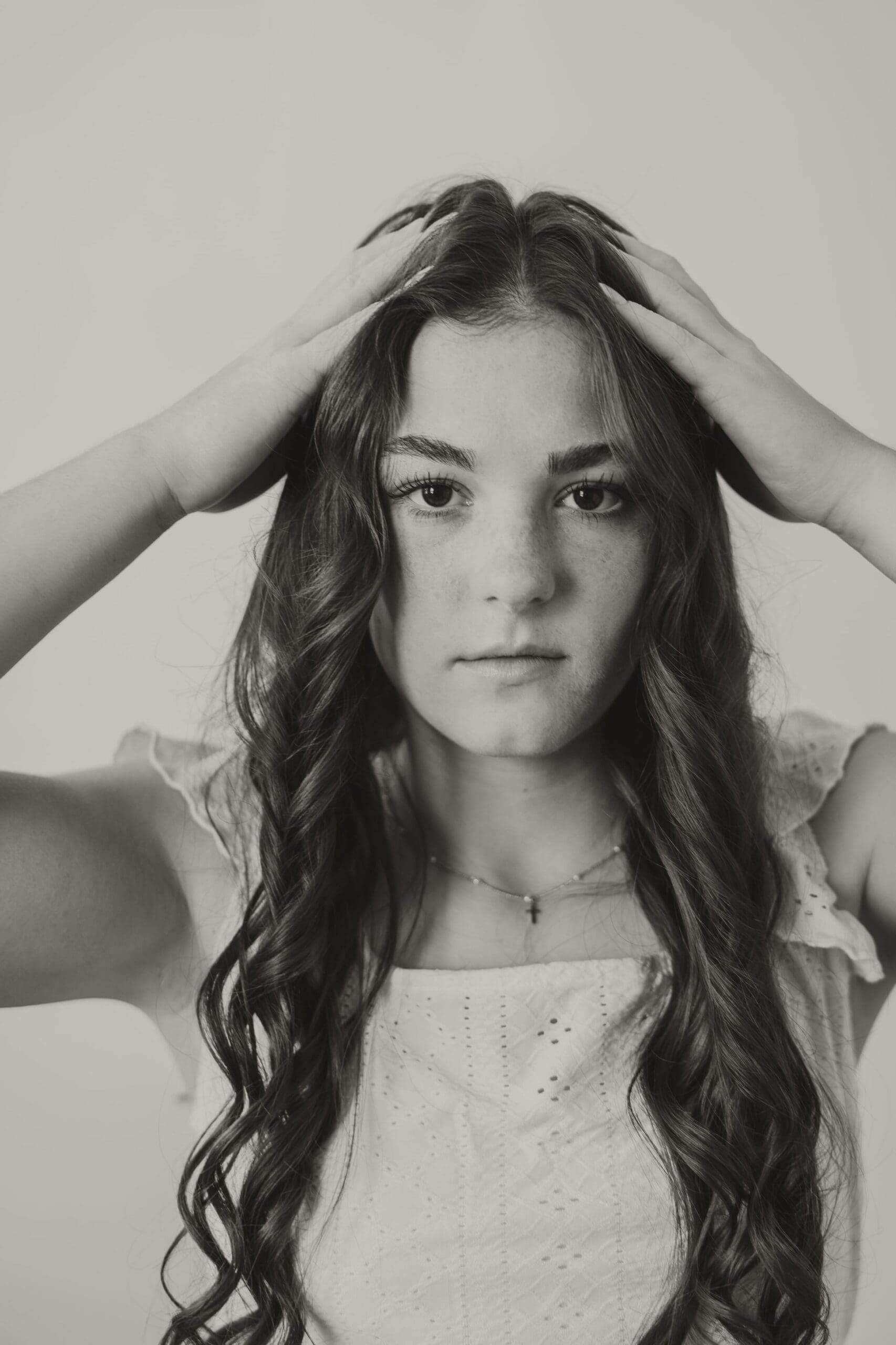 Black and white photo of senior girl touching hair