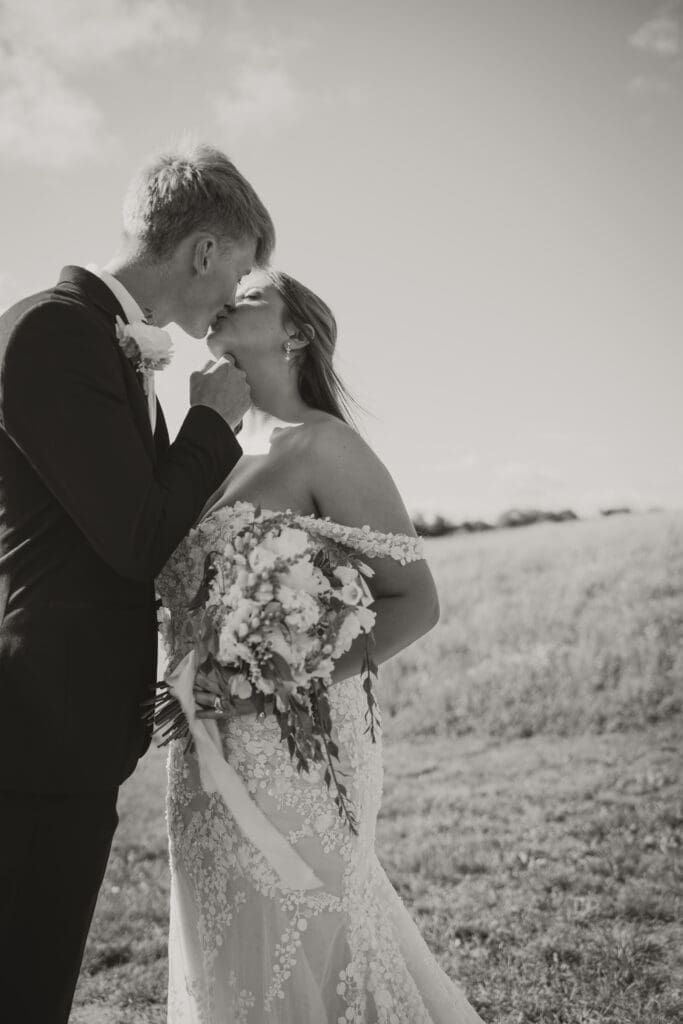 bride and groom kissing black and white photo