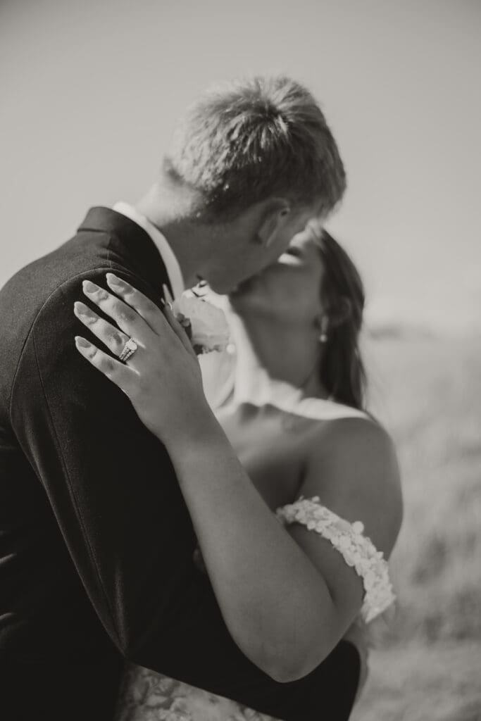 bride and groom kissing ring shot black and white