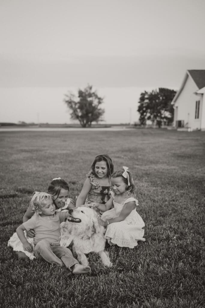black and white photo kids petting dog